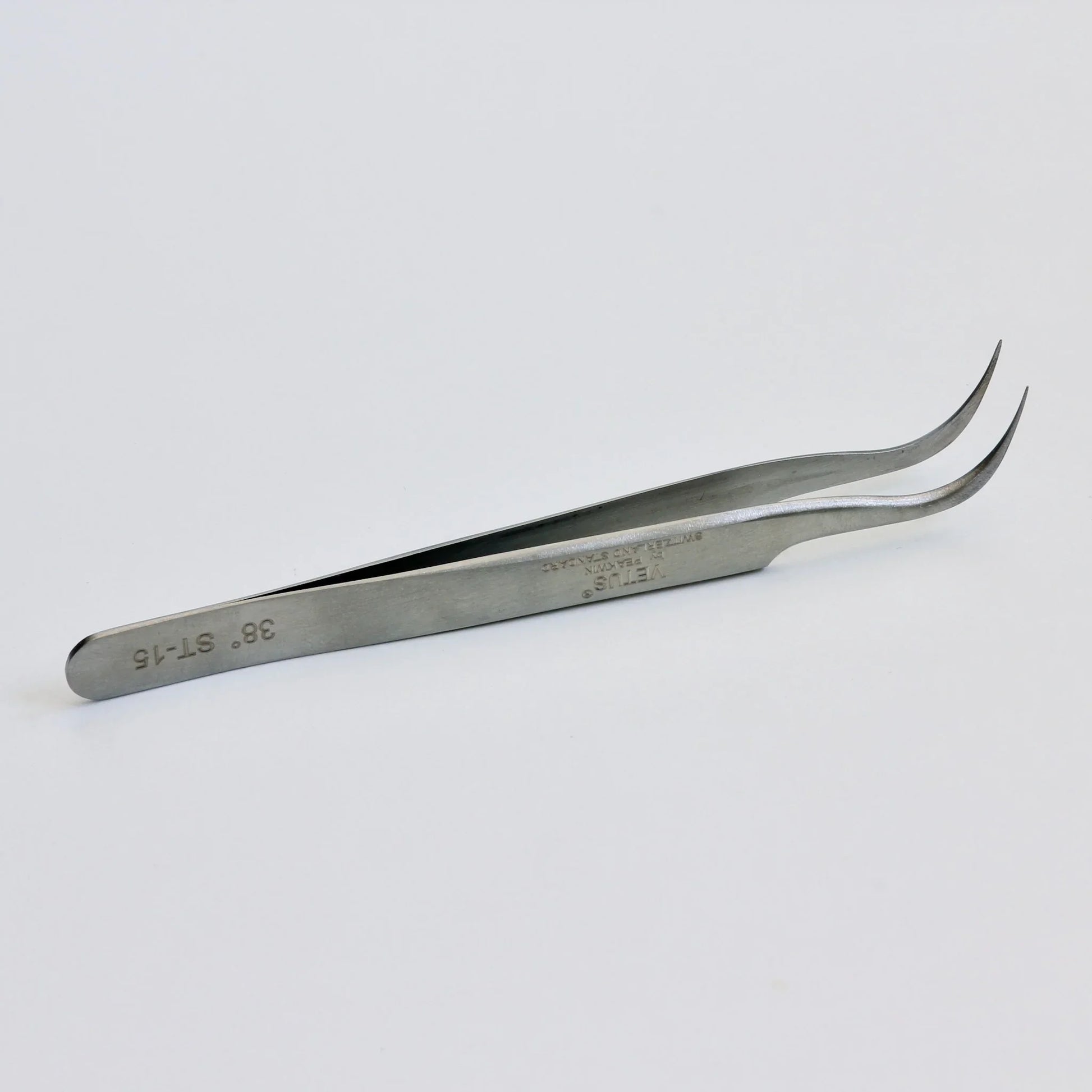 Curved tip stainless steel precision tweezers on white background