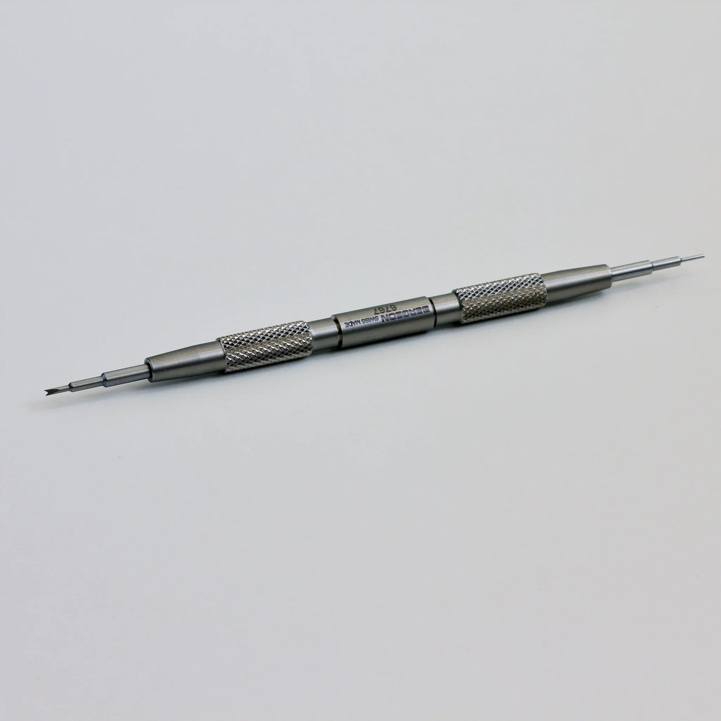 Double-ended stainless steel watch repair tool with textured grip on white background