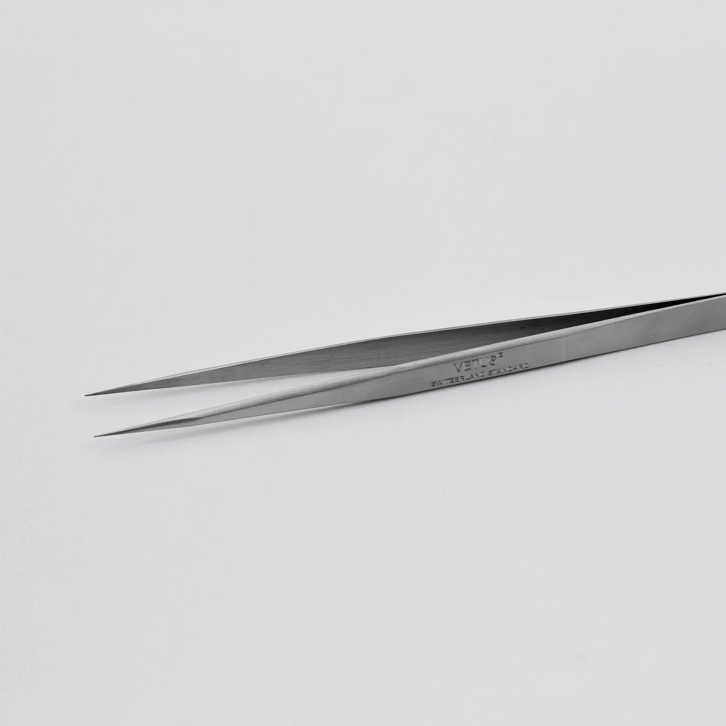 Stainless steel precision tweezers on white background